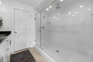 Bathroom featuring vanity, tile patterned floors, and a shower with door