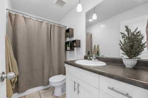 Bathroom featuring tile patterned flooring, vanity, and toilet