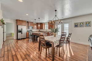 Dining space featuring a notable chandelier, light hardwood / wood-style floors, and sink