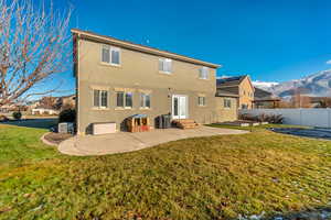 Rear view of house featuring a mountain view, a yard, a patio, and french doors