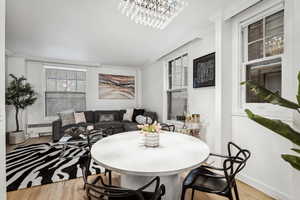 Dining room featuring light hardwood / wood-style floors, crown molding, and radiator