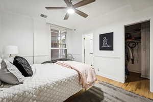 Bedroom with a closet, light hardwood / wood-style floors, ceiling fan, and crown molding