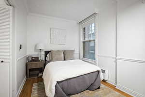 Bedroom with hardwood / wood-style floors and crown molding