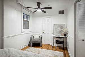 Bedroom featuring wood-type flooring, ceiling fan, and ornamental molding