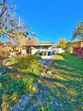 Rear view of house featuring a lawn and a patio