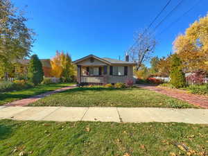 Ranch-style house with covered porch and a front yard