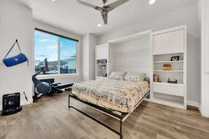 Bedroom with ceiling fan, wood-type flooring, and a textured ceiling