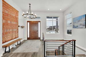 Foyer entrance featuring wood-type flooring and an inviting chandelier