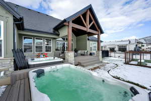 Snow covered house featuring a wooden deck