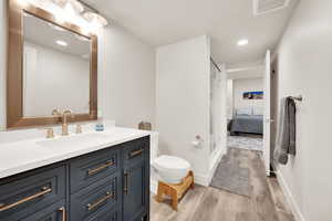 Bathroom with wood-type flooring, vanity, and toilet