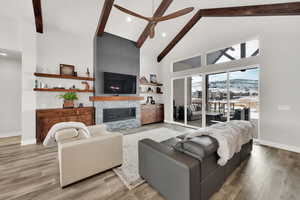 Living room with a fireplace, hardwood / wood-style floors, high vaulted ceiling, and beamed ceiling