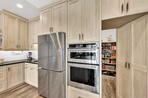 Kitchen with appliances with stainless steel finishes, light wood-type flooring, and light brown cabinets