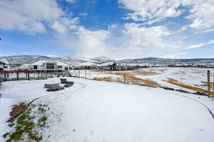 Yard layered in snow featuring a mountain view