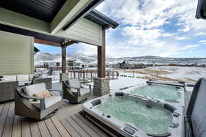 Snow covered deck featuring a mountain view