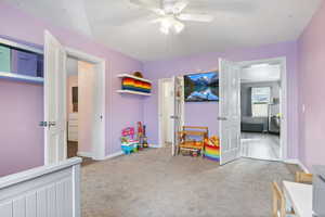 Bedroom featuring walk-in closet, carpet and ceiling fan