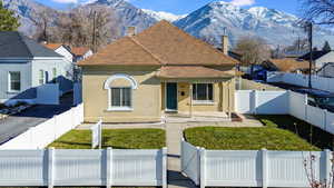 View of front of property with a mountain view, a front lawn, and covered porch