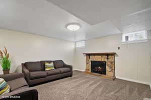 Carpeted living room with a fireplace and a textured ceiling