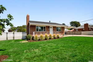 View of front facade featuring a front yard and a carport