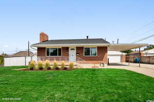 View of front facade featuring a carport, a porch, and a front lawn