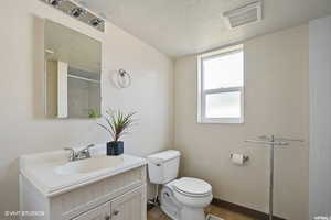 Bathroom with tile patterned floors, toilet, a textured ceiling, and walk in shower