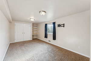 Unfurnished bedroom featuring carpet flooring and a closet