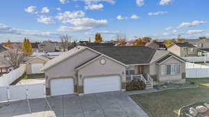 Single story home with a garage and a front lawn