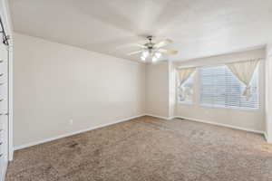 Unfurnished room with ceiling fan and carpet