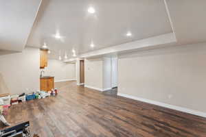 Basement with sink and dark hardwood / wood-style floors