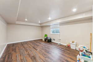 Basement with dark hardwood / wood-style floors