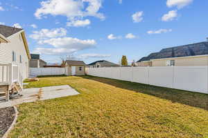 View of yard with a patio area and a storage shed