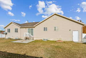 Rear view of house with a patio area and a lawn