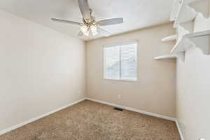 Carpeted spare room featuring ceiling fan