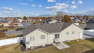 Rear view of house featuring a lawn, central AC, and a mountain view