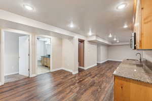 Basement with dark hardwood / wood-style flooring and sink