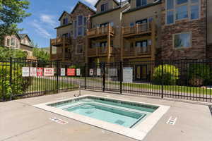 View of swimming pool with a hot tub