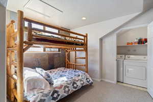 Bedroom featuring a textured ceiling, separate washer and dryer, and carpet floors