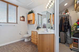 Bathroom with tile patterned floors, curtained shower, vanity, and toilet