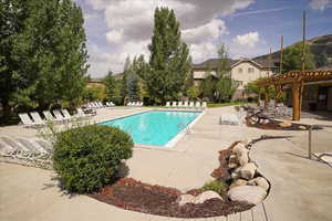 View of pool with a pergola and a patio area