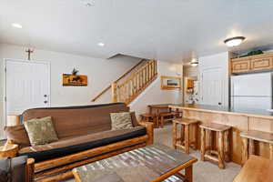 Carpeted living room with a textured ceiling