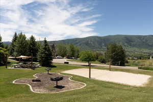 Surrounding community featuring a mountain view, volleyball court, and a lawn