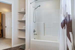 Bathroom with tile patterned floors and shower / bath combo