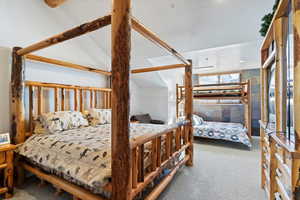 Bedroom featuring a textured ceiling, carpet floors, and lofted ceiling