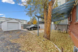 View of yard featuring a carport, an outdoor structure, and a garage