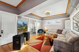 Living room with wood-type flooring and ornamental molding