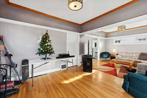 Living room with light hardwood / wood-style floors and ornamental molding