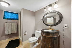 Bathroom with tile patterned floors, vanity, and toilet