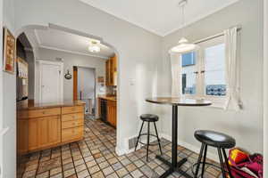 Kitchen featuring dishwasher, hanging light fixtures, and crown molding