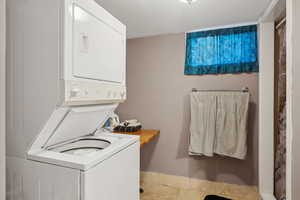 Washroom featuring stacked washing maching and dryer