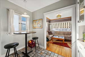 Dining space with light wood-type flooring and crown molding