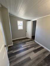 Unfurnished bedroom featuring dark hardwood / wood-style flooring, a closet, and crown molding